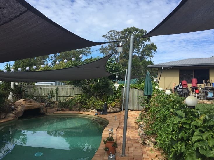 3 shade sails over a pool